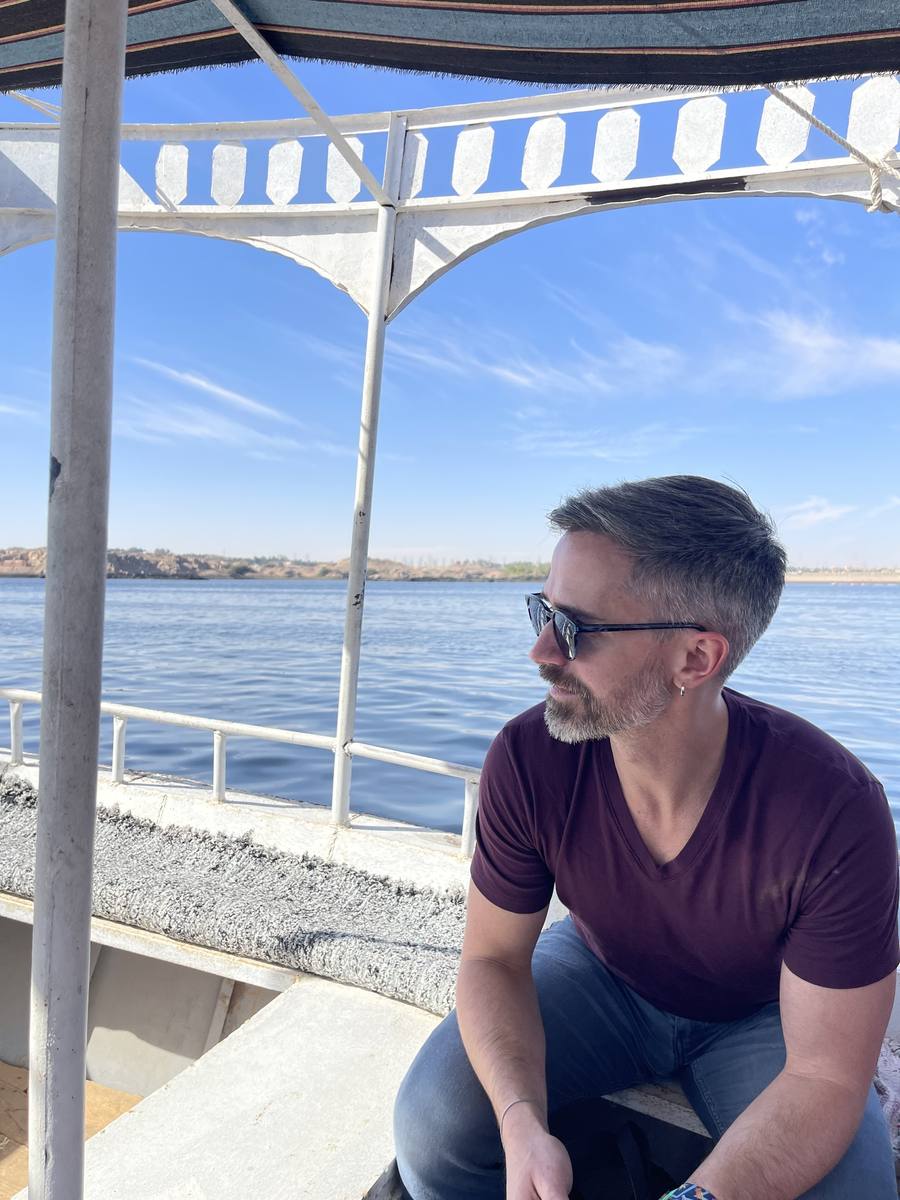 Adam on a boat on the Nile, looking out over the water